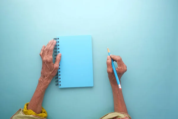 Верхний вид пожилых женщин, пишущих от руки на блокноте. — стоковое фото
