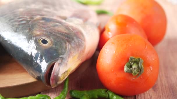 Roher frischer Fisch auf einem Schneidebrett zur Vorbereitung auf das Kochen auf dem Tisch , — Stockvideo
