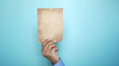 Renk arkaplanına karşı boş bir kağıt tutmak 