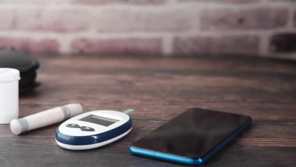 Smartphone und Diabetikermessgeräte und Pillen auf dem Tisch — Stockvideo