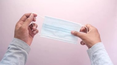  Adam elinde cerrahi maske tutuyor, yakın plan. 