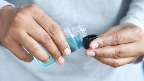 Hand hold a mouthwash liquid container — Stock Video