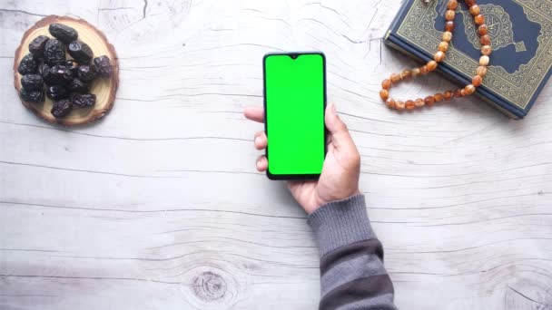 Smart phone, Heilige boek Koran en rozenkrans op tafel, — Stockvideo