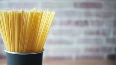 Masadaki konteynırda sarı uzun spagetti. 