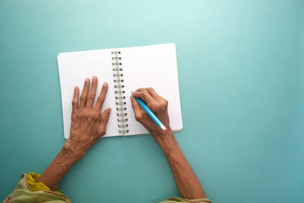 Вид сверху пожилой женщины рукой на бланке бумаги на столе — стоковое фото