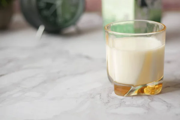 Primer plano de vaso de leche y cuchara en la mesa — Foto de Stock