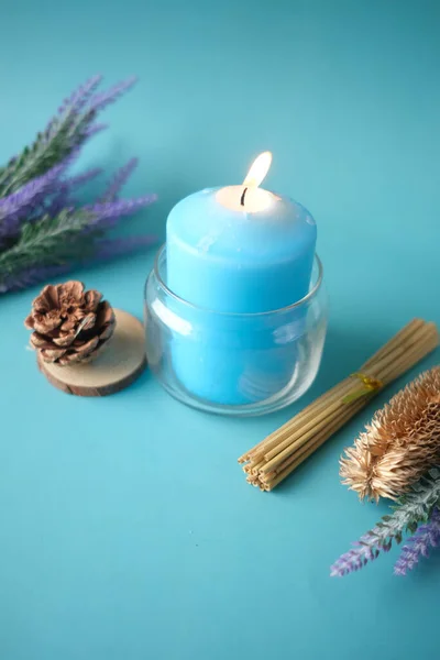 Candela naturale in un vaso di vetro e fiori secchi su blu — Foto Stock