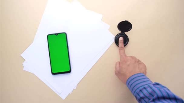 Verschillende zwarte vingerafdrukken op papier en smartphone met groen scherm — Stockvideo