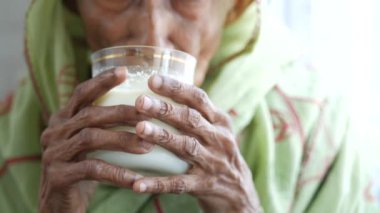 Yaşlı Asyalı kadınlar süt içiyor. 