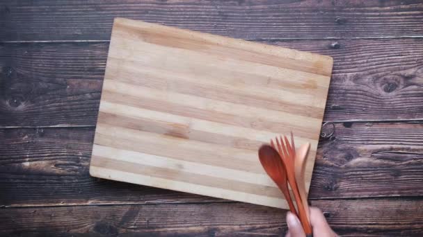 Tabla de cortar de madera y cuchara en la mesa — Vídeo de stock
