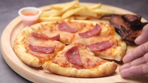 Bir tabaktan bir dilim pizza toplayan adama yaklaş. — Stok video