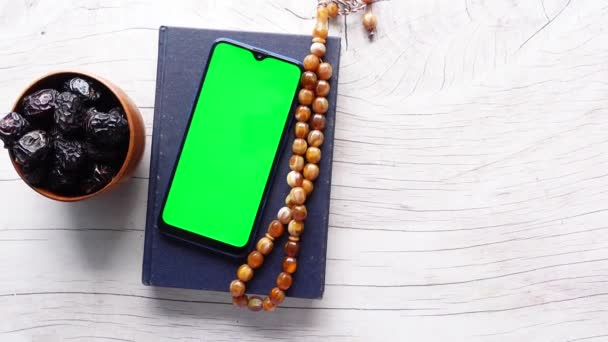 Smart phone, Heilige boek Koran en rozenkrans op tafel, — Stockvideo