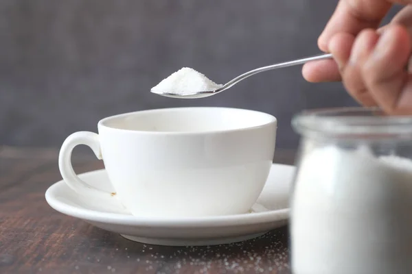 Gießen weißen Zucker in einer Teetasse — Stockfoto