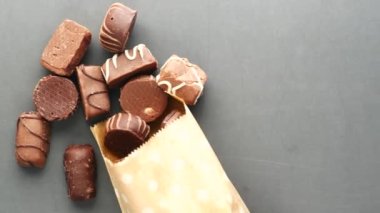 Koyu çikolata dökülmesi siyah üzerine kağıt bir paket oluşturur. 