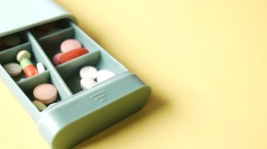 Tıbbi hapları masanın üzerindeki ilaç kutusuna koy. 