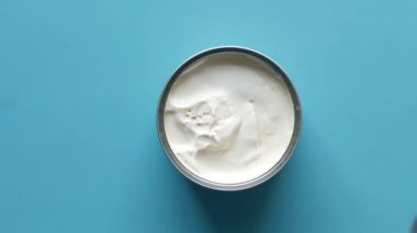 Süt kremasının mavi arka plandaki konteynırdaki üst görüntüsü,