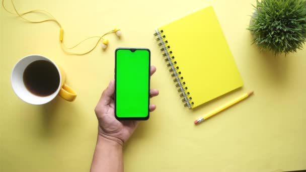 Vista superior do homem mão usando telefone inteligente no fundo amarelo — Vídeo de Stock