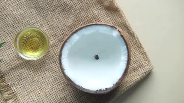 Slice of fresh coconut and bottle of oil on a table — Stock Video