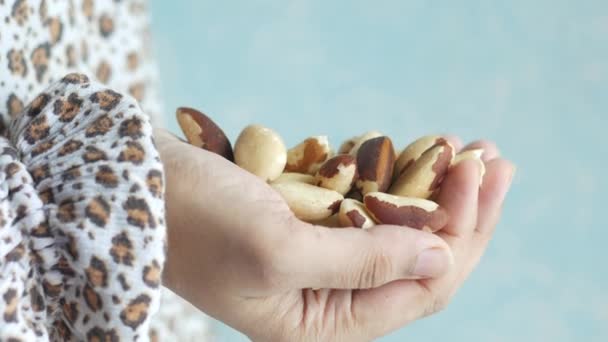 Mujeres comiendo nuez brasileña de cerca — Vídeos de Stock