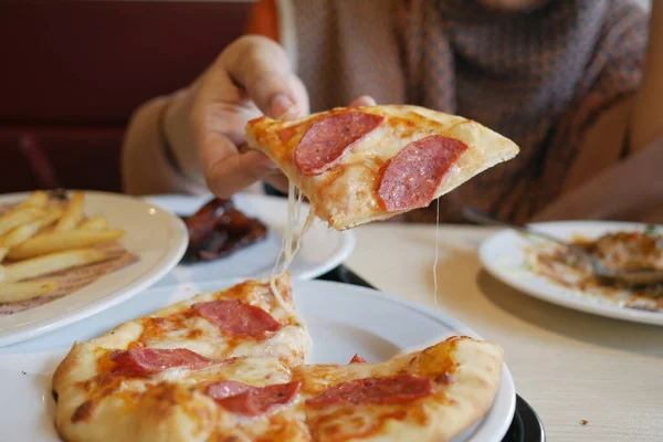 Donne mano raccogliendo fetta di pizza da un piatto — Foto Stock