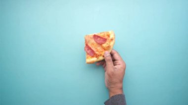 Mavi üzerine bir dilim pizza tutmanın en iyi görüntüsü. 