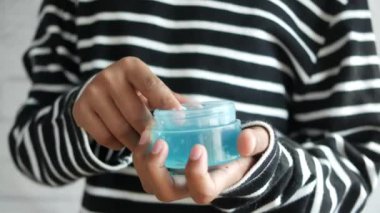 Bir kavanoz saç jölesini tut.,