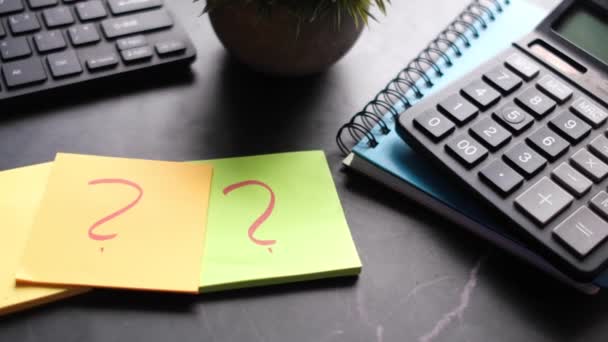 オフィスの机の上の紙の上の質問マークの高い角度表示 — ストック動画