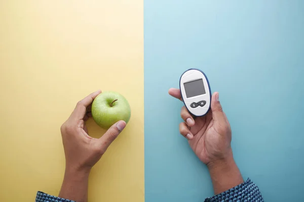 拿着糖尿病测量工具，苹果放在桌上 — 图库照片