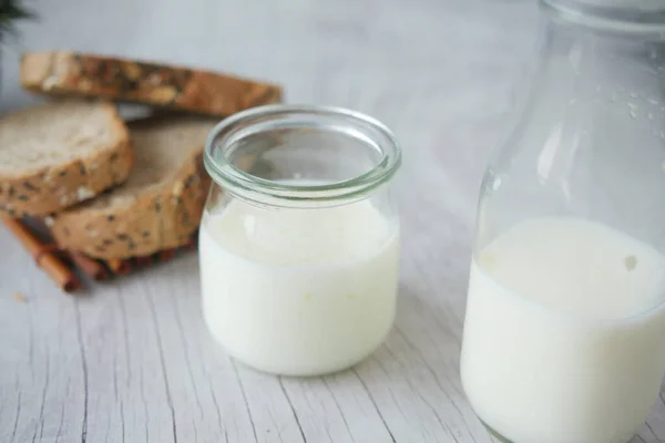 Крупним планом склянка молока і коричневого хліба на столі — стокове фото