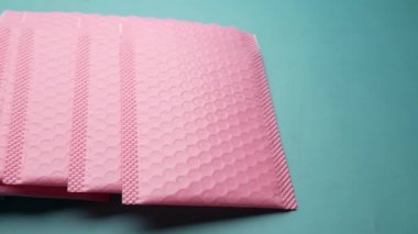  Masanın üzerinde pembe ve yeşil renkli kağıt baloncuk zarfı 