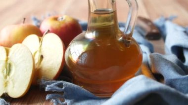 Cam şişede elma sirkesi ve masada taze yeşil elma. 
