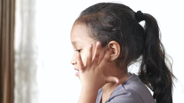 Девочка с болью в ухе трогает его болезненное ухо , — стоковое видео