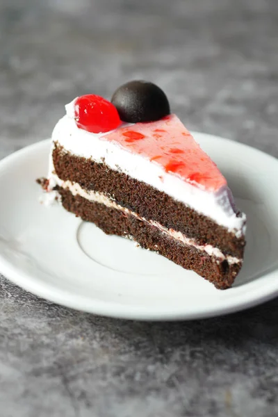 Pastel de chocolate y crema en un plato en la mesa — Foto de Stock