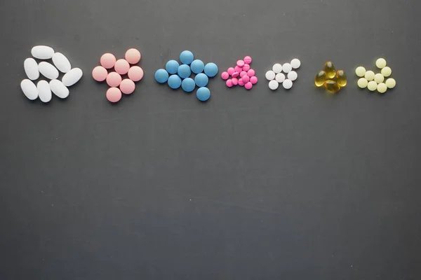 Draufsicht auf alle bunten Pillen und Kapseln auf schwarzem Hintergrund — Stockfoto