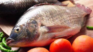 Yemek yapmaya hazırlanmak için doğrama tahtasındaki çiğ taze balık. ,