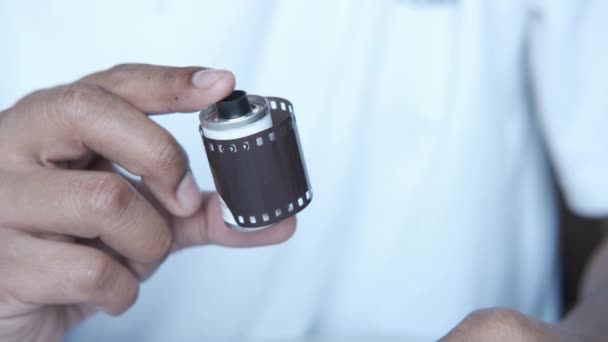 Holding camera with film rolls — Vídeos de Stock