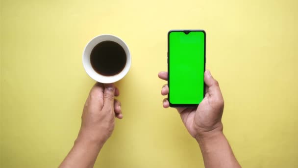 Vista de ángulo alto de la mano de los hombres usando el teléfono inteligente y beber café — Vídeos de Stock