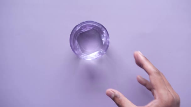 手拿杯紫色底色的水 — 图库视频影像