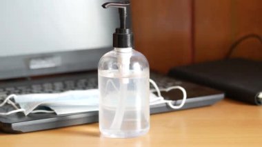 Masadaki mavi cerrahi maskeleri ve el dezenfektanını kapat. 