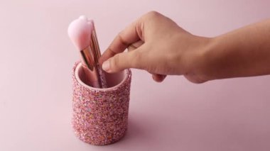 Açık mor arkaplanda bir kutuda güzellik fırçası 