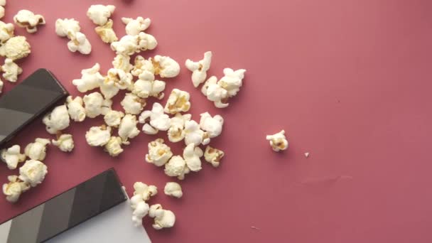 Filmklappbrett und Popcorn auf rotem Hintergrund — Stockvideo