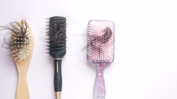 Wiele szczotka z utraconych włosów na jasnym fioletowym tle — Wideo stockowe