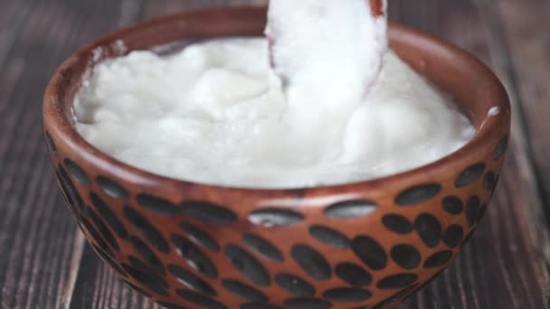 Yogurt fresco en un tazón sobre la mesa — Vídeo de stock
