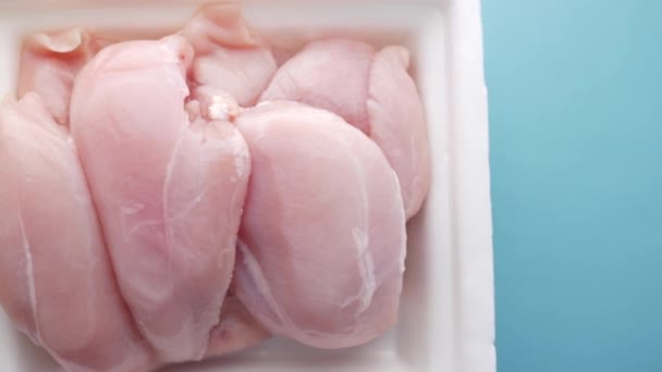 Pechuga de pollo cruda en un paquete sobre la mesa — Vídeos de Stock