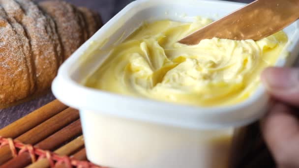 Mentega segar dalam wadah dengan roti di latar belakang putih — Stok Video