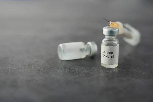 Fechar de perto a vacina contra o coronavírus e seringa — Fotografia de Stock
