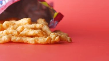 Patates cipsi kırmızı paketten dökülüyor. 
