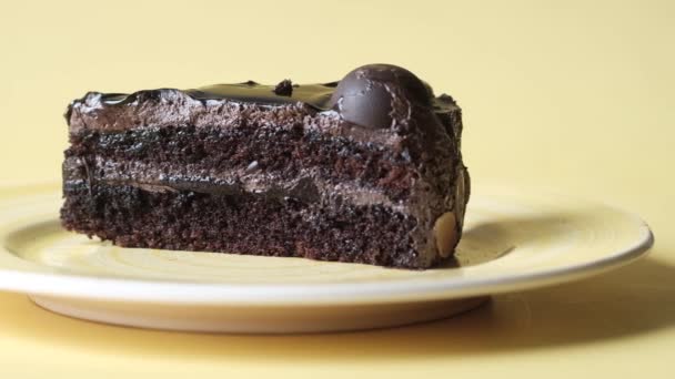 Pastel de chocolate y crema en un plato en la mesa — Vídeos de Stock