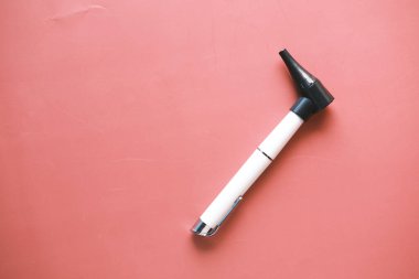  Kırmızı arkaplanda otoskop inceleniyor 