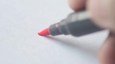mans hand writing with red color sing pen 
